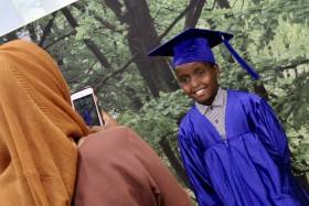 Parent photographing their child at graduation